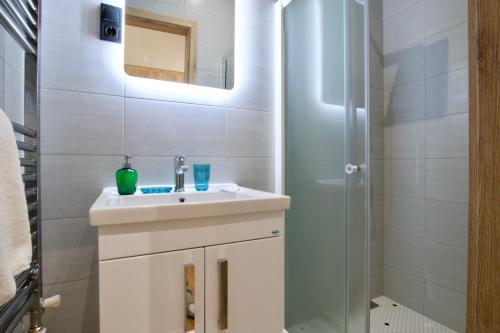 a white bathroom with a sink and a shower at Standard Apartment by Hi5 - Anker 1 in Budapest
