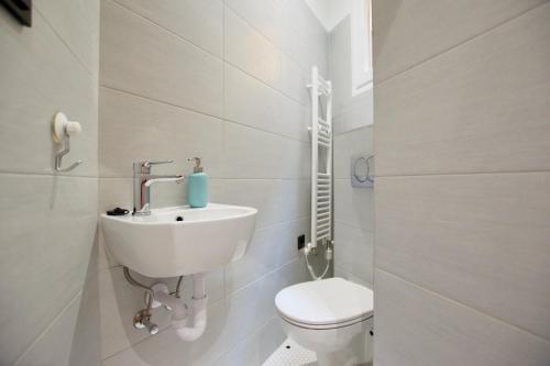 a white bathroom with a toilet and a sink at Standard Apartment by Hi5 - Anker 1 in Budapest