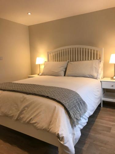 a bedroom with a large white bed with two lamps at Bush House Accommodation - The Diamond in Bushmills