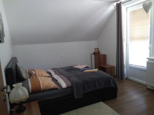 um quarto com uma cama e uma janela em apartman Lusy em Veľká Lomnica