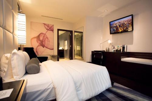 a bedroom with a white bed and a tv on the wall at Ivy Boutique Hotel in Chicago