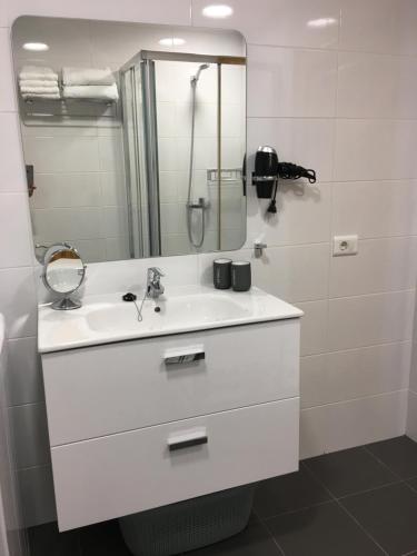 y baño blanco con lavabo y ducha. en Apartamento Primera Línea Playa de Las Canteras, en Las Palmas de Gran Canaria