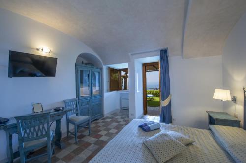 een slaapkamer met een bed, een bureau en een tafel bij Villa Il Frantoio and Lilmar in Praiano