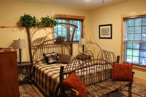 1 dormitorio con cama, banco y ventanas en Inn at the River, en Wausau