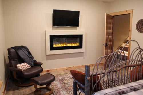 a living room with a fireplace with a tv on a wall at Inn at the River in Wausau
