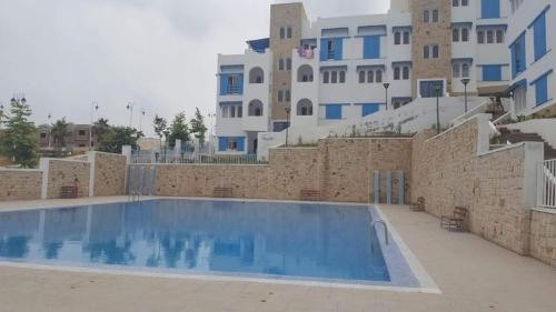 a large swimming pool in front of a building at Résidence Lilia Al Jabal M’diQ in M'diq
