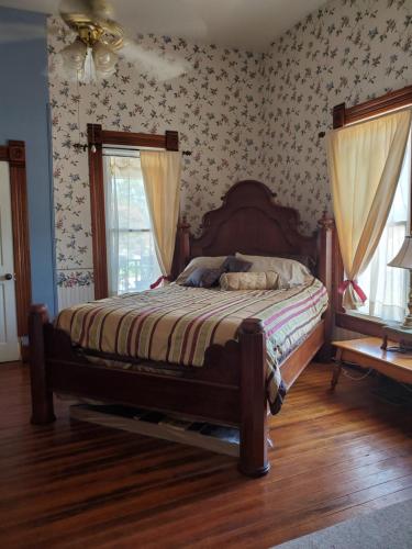 a bedroom with a bed in a room with wallpaper at 1890 Karcher Haus in Llano