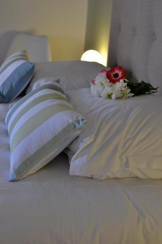 a bed with two pillows and flowers on it at 5 Chambres en Ville in Clermont-Ferrand