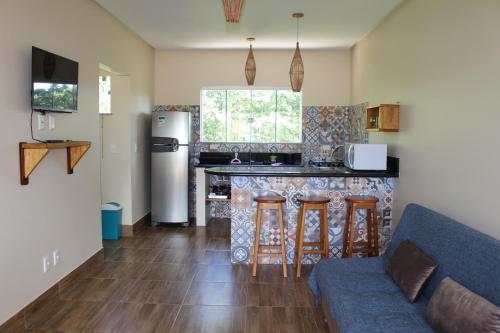 a living room with a couch and a kitchen at PachaMama Flats - Taipu de Fora in Barra Grande