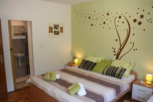 een slaapkamer met een groot bed met groene muren bij Apartment Marin - 40 m from sea in Ston