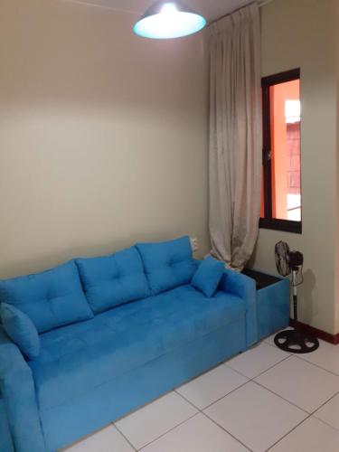 a blue couch in a living room with a window at Max Garden and Pool in Paramaribo