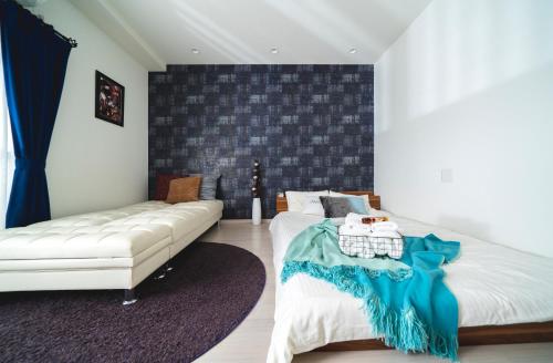 a bedroom with a white bed and a couch at K&K Apartment Kita-Akabane #202 in Tokyo