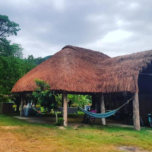 a straw hut with a hammock in front of it at Cabañas Mannan in Tanchachín