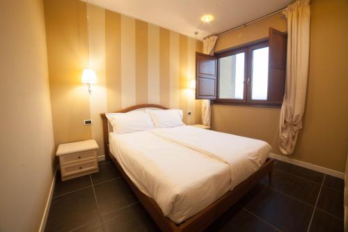 een kleine slaapkamer met een bed en een raam bij Roccamonfina Palace Hotel in Roccamonfina