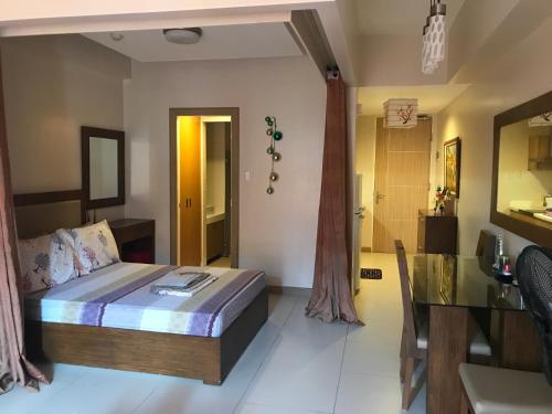 a bedroom with a bed and a dining room at Creys condo at Pico de Loro Cove in Nasugbu