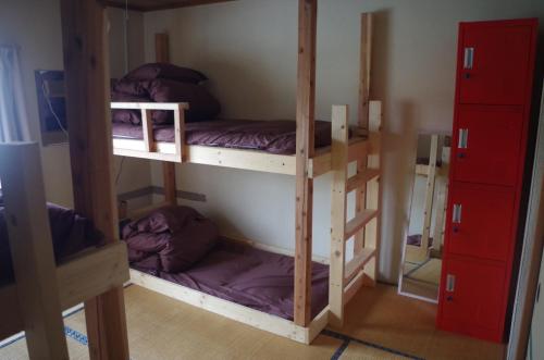 מיטה או מיטות קומותיים בחדר ב-Kusatsu Onsen Guesthouse Gyoten