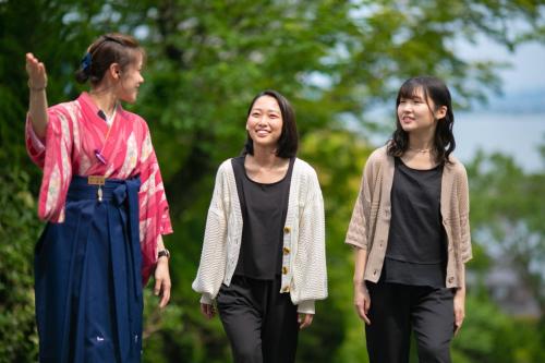 a group of three women walking down a path at Biwako Hanakaido in Otsu
