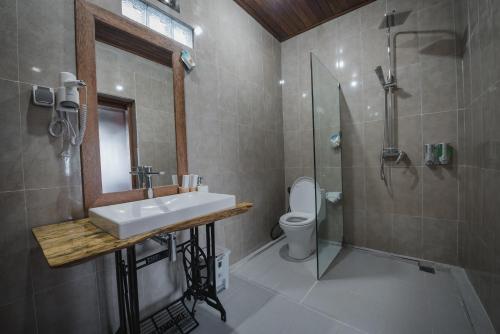 a bathroom with a sink and a shower and a toilet at Daphila Cottage in Nusa Penida