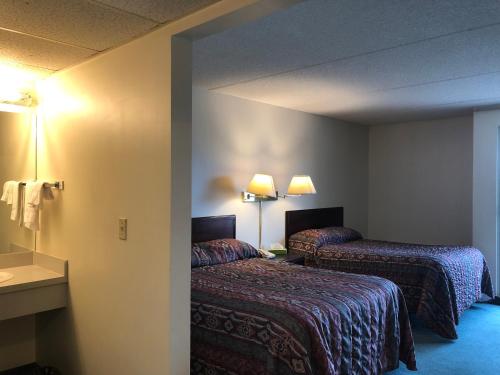 a hotel room with two beds and a sink at Westwind Motor Inn Hotel in Drayton Valley