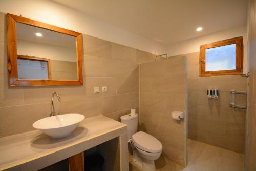 a bathroom with a sink and a toilet and a mirror at World BnB in Labuan Bajo