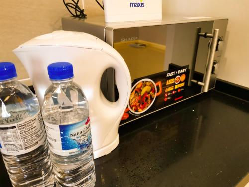 two bottles of water sitting next to a toaster at Legoland D'PRISTINE Apartment By TGP in Nusajaya