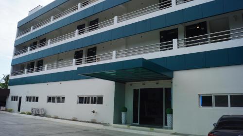 邦勞的住宿－Panglao Sea Resort - Tangnan，一座蓝色和白色的建筑,设有停车场