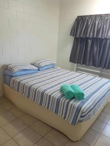 a bed with two green towels on top of it at Anchor In Holiday Units South Mission Beach in South Mission Beach