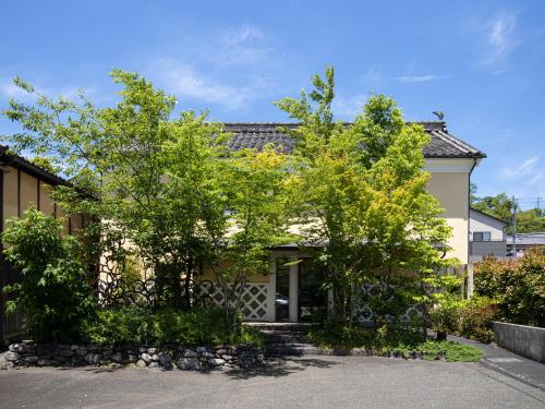 a house with two trees in front of it at 内子の宿 くら in Uchiko