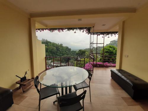 a dining room with a glass table and a balcony at Nature Walk Resort in Kandy