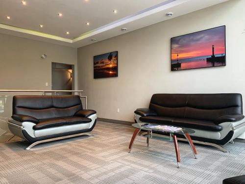 two leather couches and a table in a living room at Amber Hotel in Grand Bend