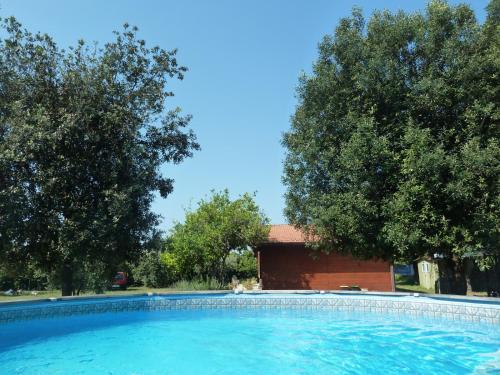 a swimming pool in front of a building with trees at 'O Chalet in Pozzuoli