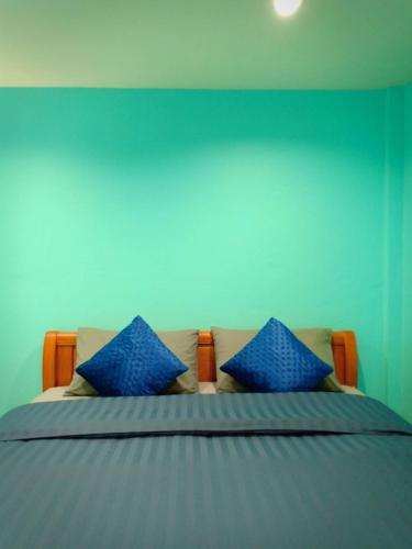 a bedroom with a bed with blue walls and blue pillows at Siri Guesthouse in Phra Nakhon Si Ayutthaya