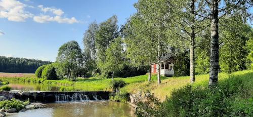 a small cabin next to a river with a waterfall at Störsby Bed & Breakfast in Lappers