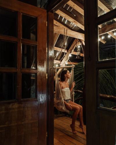 a woman sitting in a hammock in a room at Natura Vista in Panglao