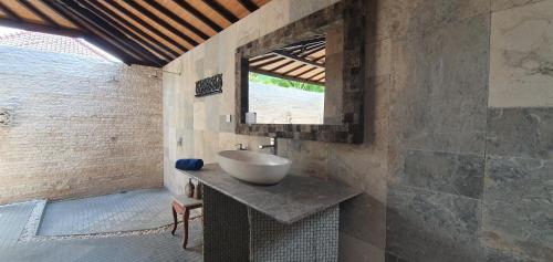 baño con lavabo y ventana en Coral View Villas, en Amed