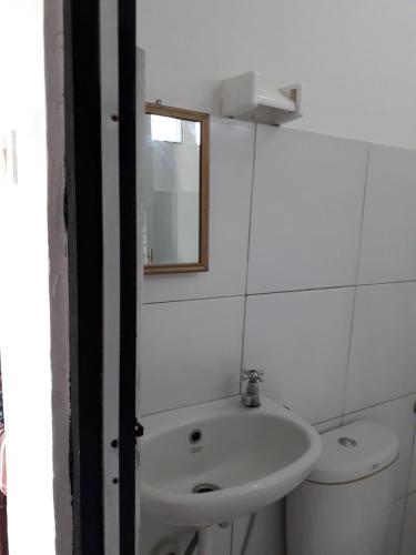 a white bathroom with a sink and a toilet at Rinjani Houseboon in Senaru