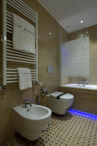 a bathroom with a sink and a tub and a toilet at The Queen Luxury Apartments - Villa Carlotta in Luxembourg