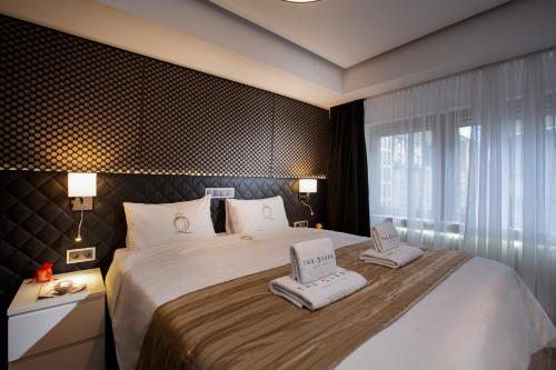 a bedroom with a large bed with towels on it at The Queen Luxury Apartments - Villa Carlotta in Luxembourg