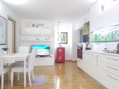 een witte keuken met een tafel en een rode koelkast bij White Dream Suites in Iaşi