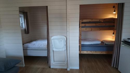 a small room with two bunk beds and a mirror at Tornby Strand Camping Cottages in Hirtshals