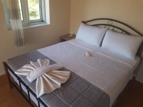 a bed with two towels sitting on top of it at Villa Xani in Himare