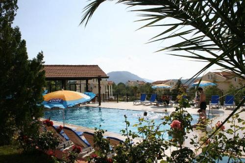 a large swimming pool with chairs and umbrellas at Eftelya Apart in Oludeniz