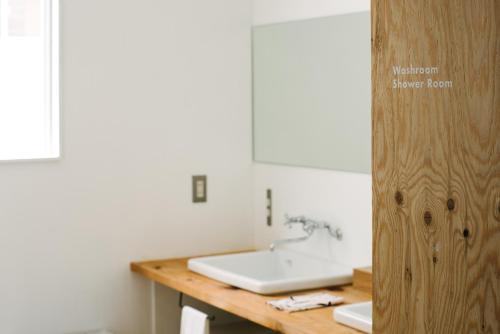a bathroom with a sink and a wooden counter at WhyKumano in Nachikatsuura