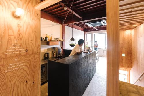 a man standing at a counter in a kitchen at WhyKumano in Nachikatsuura