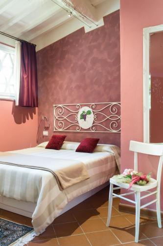 a bedroom with a large bed with pink walls at Fattoria Pogni in Marcialla