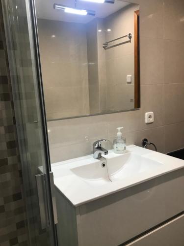 a bathroom with a sink and a mirror at Apartamento céntrico en Formigal in Formigal