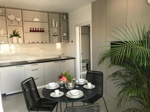 a dining room with a table and chairs and a kitchen at Levante Holiday Apartments in Larnaca