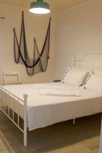 a white bed with a hammock hanging on the wall at VILA BUNICUTA in Eforie Sud