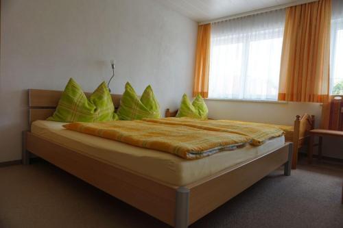 - une chambre avec un grand lit et des oreillers verts dans l'établissement Gästehaus Jedinger, à Sankt Georgen im Attergau