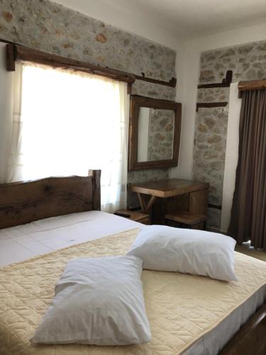sypialnia z łóżkiem, oknem i biurkiem w obiekcie Vila Ilo w mieście Tushemisht